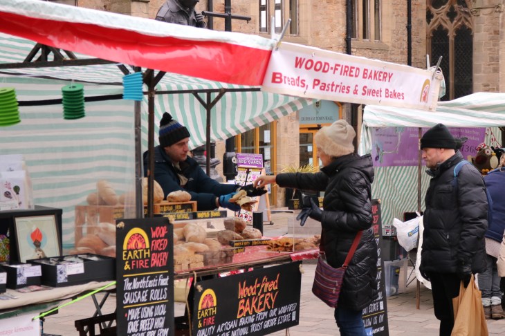 Customers purchasing bread from a Christmas market